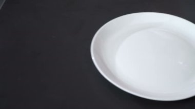 Cook jambon bir tabağına koyuyor.