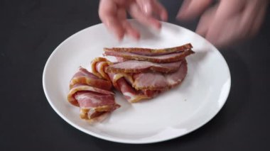 Cook jambon bir tabağına koyuyor.