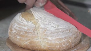 Baker sıcak taze ekmek keser. ağır çekim