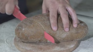 Baker sıcak taze ekmek keser. ağır çekim