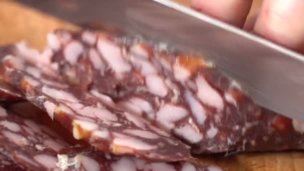 The cook cuts a knife smoked sausage — Stock Video