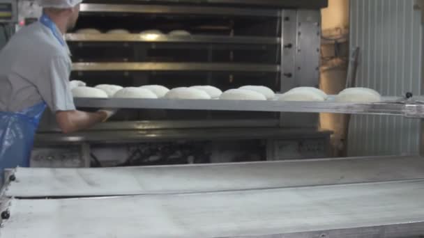 Bakers load bread dough into oven. slow motion — Stock Video