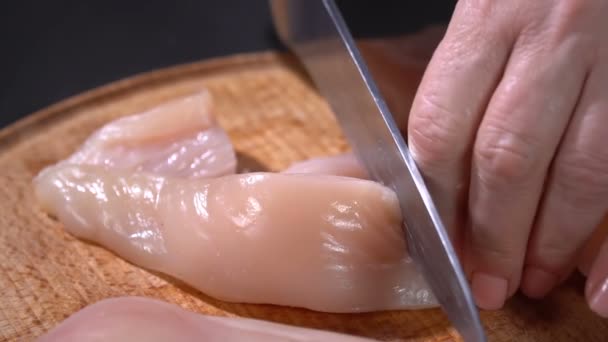De kok snijdt met een mes-kipfilet — Stockvideo
