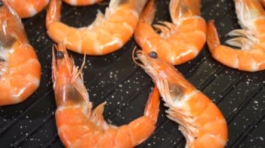 Bir tavada deniz karides hazırlayın. Ağır çekim