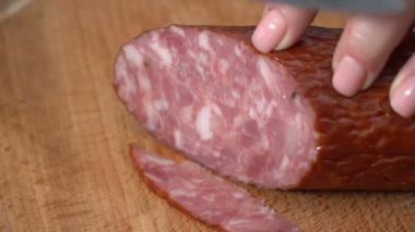 Tütsülenmiş sosis bir bıçak ile kesmek. ağır çekim