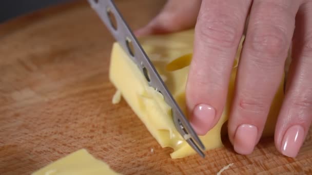 Kaas met gaten met een mes gesneden. Slow motion — Stockvideo