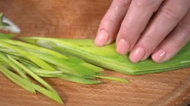 Bir kesme tahtası üzerinde kesme pırasa. ağır çekim