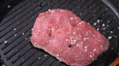 Çiğ biftek bir tencerede kızartılır. ağır çekim