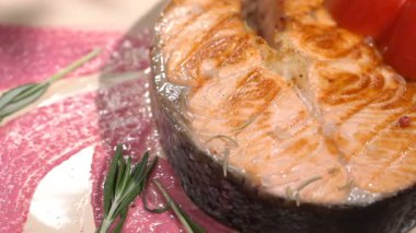 Somon steak plakalı rosemary ile serpilir. Ağır çekim 100f