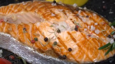 Bir tavada somon steak tuz ve baharatlar ile serpilir. Ağır çekim 100f