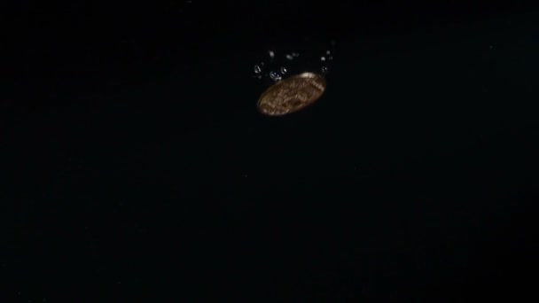 比特币硬币落在黑色背景下的水中 慢动作 — 图库视频影像