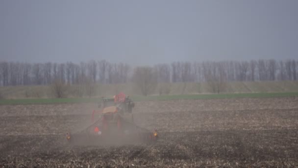 El tractor siembra un campo en primavera — Vídeos de Stock