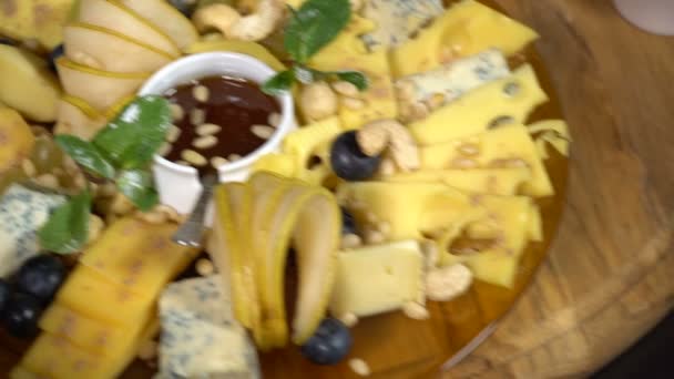 Fatias de queijo com nozes, mel e frutas — Vídeo de Stock