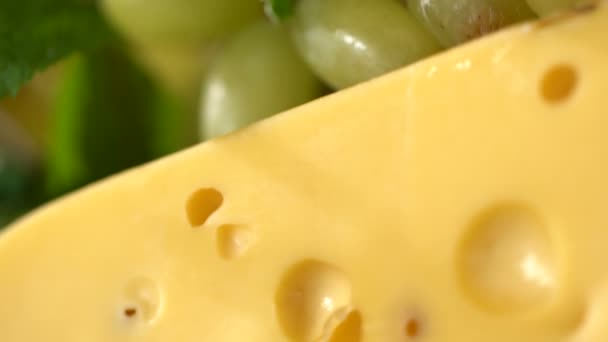 Hard cheese with holes and grapes — Stock Video