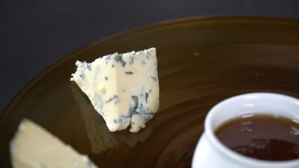 Повар кладет кусочки сыра на тарелку — стоковое видео