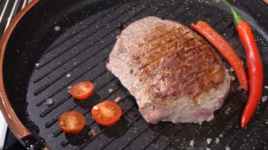 Bir tavada kızarmış biftek domates ile