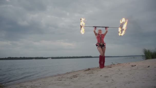 Дівчина з вогнем біля річки — стокове відео