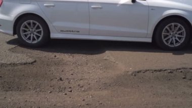 Arabalar çukurlar ile yol boyunca sürücü