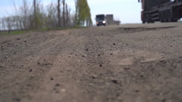 Carros dirigem ao longo da estrada com buracos — Vídeo de Stock