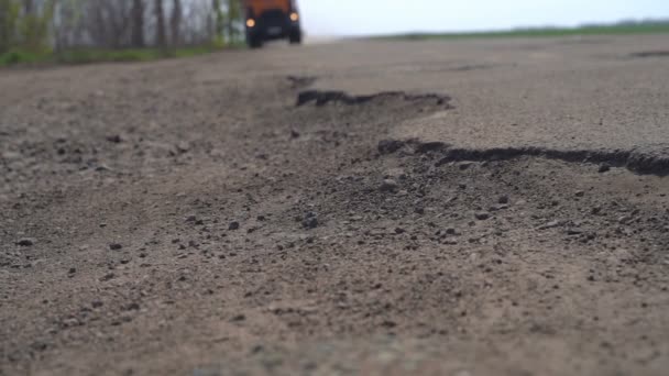 Voitures roulent le long de la route avec des nids de poule — Video