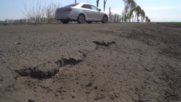 Autók meghajtó az út mentén a potholes — Stock videók