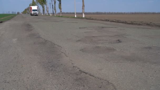 Carros dirigem ao longo da estrada com buracos — Vídeo de Stock