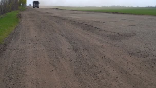 Autók meghajtó az út mentén a potholes — Stock videók
