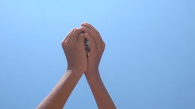 Deniz kabukları ellerinden akıyor.