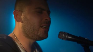 Müzisyen mikrofona şarkı söylüyor