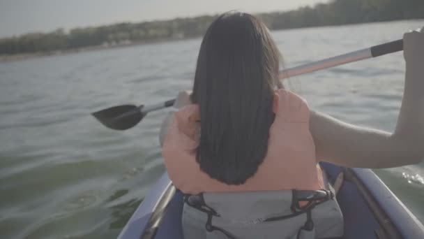 Girl floats in a kayak boat. Slow motion — ストック動画