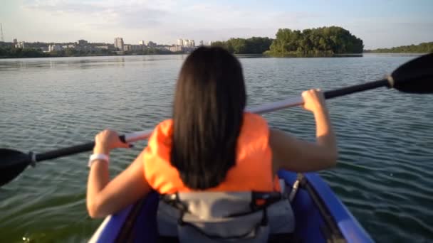 Girl floats in a kayak boat. Slow motion — ストック動画