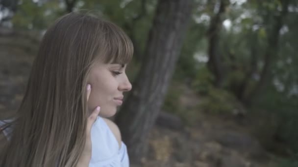 Girl sitting on a stone by the river — ストック動画