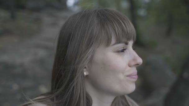 Девушка сидит на камне у реки — стоковое видео
