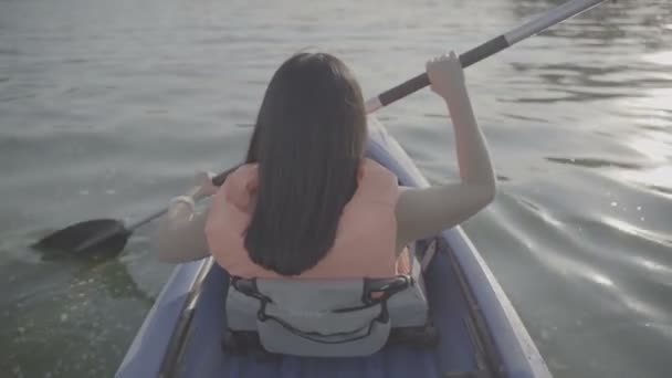 Girl floats in a kayak boat — ストック動画
