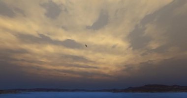 4 k Eagles yüksek gökyüzü, göl ve dağ gezinip, parlak güneş ve bulut, alacakaranlıkta.