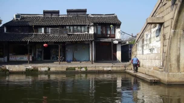 Chinês antigo horário & ponte, mulher velha vacilante, cidade água vida residente . — Vídeo de Stock