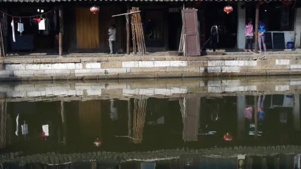 Traditional Chinese houses & bridge reflection on blue water, XiTang Water Town . — стоковое видео