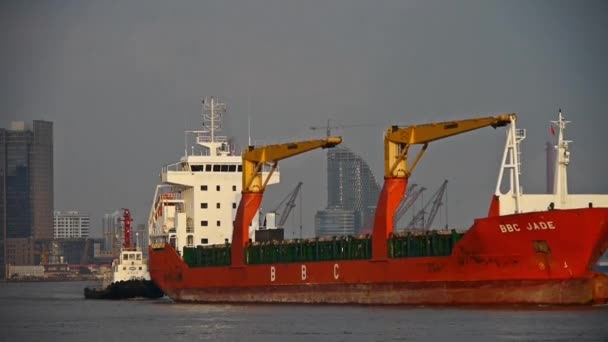 Rødt fragtskib med båd passerer Af shanghai bund, moderne bygning baggrund . – Stock-video