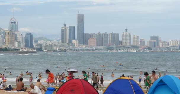 4k πολλοί άνθρωποι στην πολυσύχναστη αμμώδη παραλία. Άνθρωποι κολύμπι στη θάλασσα, Qingdao, Κίνα. — Αρχείο Βίντεο