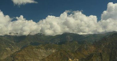 kitle Tibet dağın ve vadi, dünyanın çatısı üzerinde inişli çıkışlı 4k kabarık bulutlar.