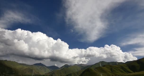 4k timelapse puffy clouds mass rolling over Tibet mountaintop & valley. — Stock Video