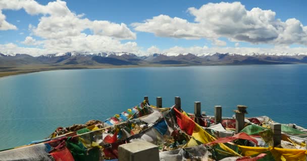 4 k enorme wolken massa kantelen meer namtso & sneeuw berg, bidden vlag in de wind. — Stockvideo