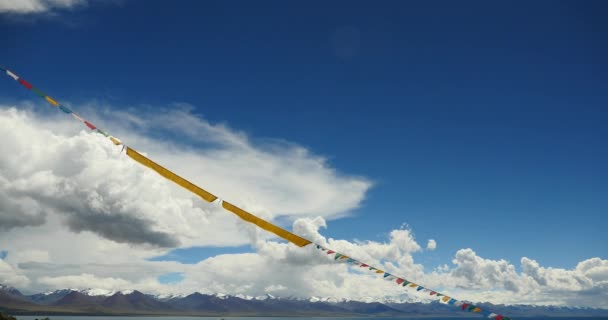 4k huge clouds mass rolling over lake namtso & snow mountain,pray flag in wind. — Stock Video