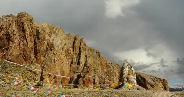 4 k flagi modlitewne na jeziorem nam co w Tybecie, mnich starożytnych medytacji w jaskini. — Wideo stockowe