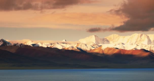 4k salida del sol enormes nubes rodando sobre el lago namtso & montaña de nieve en el Tíbet . — Vídeos de Stock