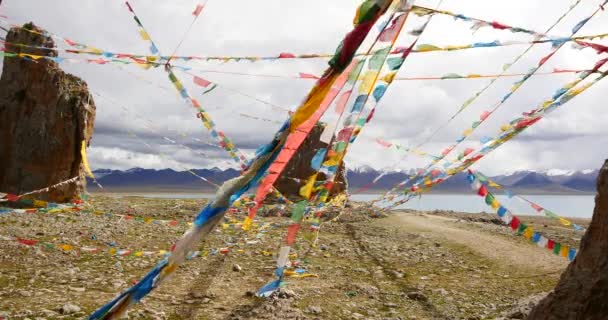 4k huge clouds mass rolling over lake namtso & snow mountain,pray flag in wind. — Stock Video