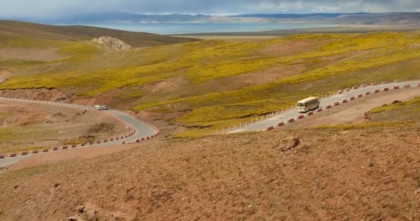 4k coche de conducción en el camino meandro, la distancia lago namtso & montaña en el Tíbet . — Vídeos de Stock