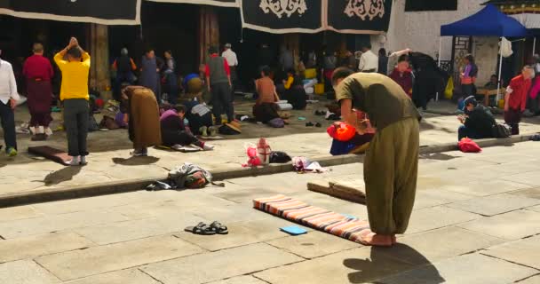 4k Pilgramos orando frente al templo de Jokhang en Lhasa, Tíbet . — Vídeos de Stock