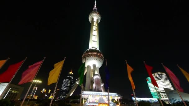 Shanghai Oriental Pearl Tower med flygande flg nattetid. — Stockvideo