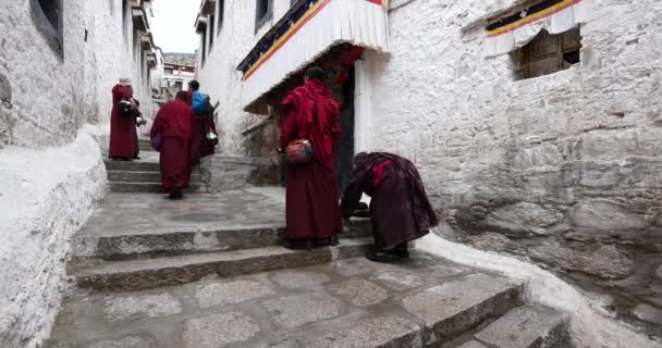 4k monjes del Tíbet caminando sobre el lhasa drepung, famoso templo tibetano . — Vídeo de stock